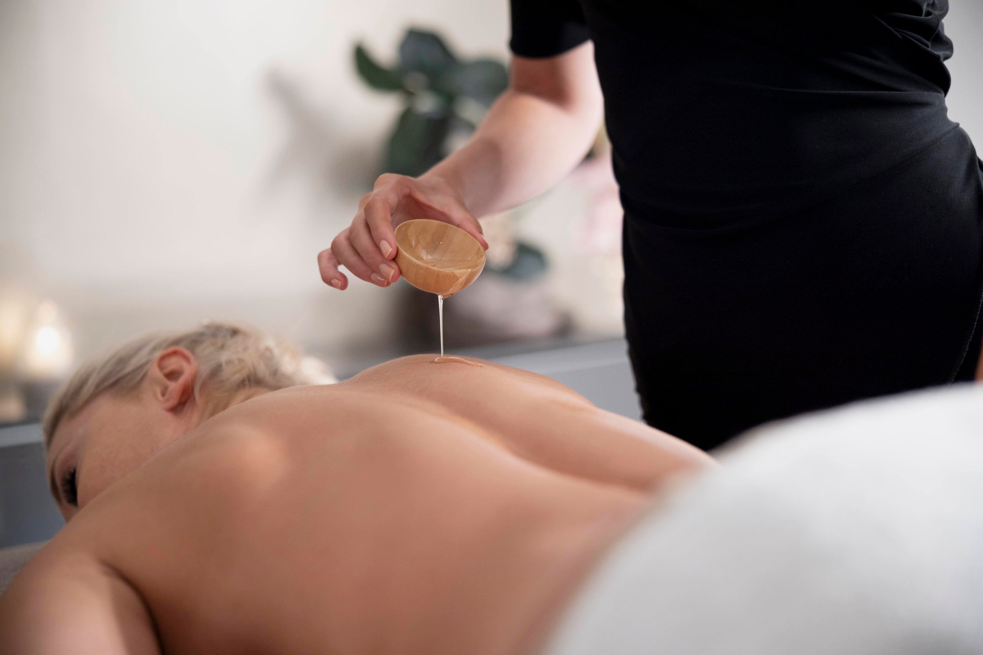 young-woman-using-massage-oil-her-client